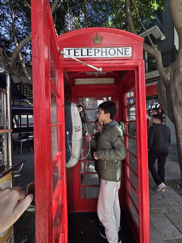 Nico dentro de una cabina de teléfono británica roja en una calle de Gibraltar