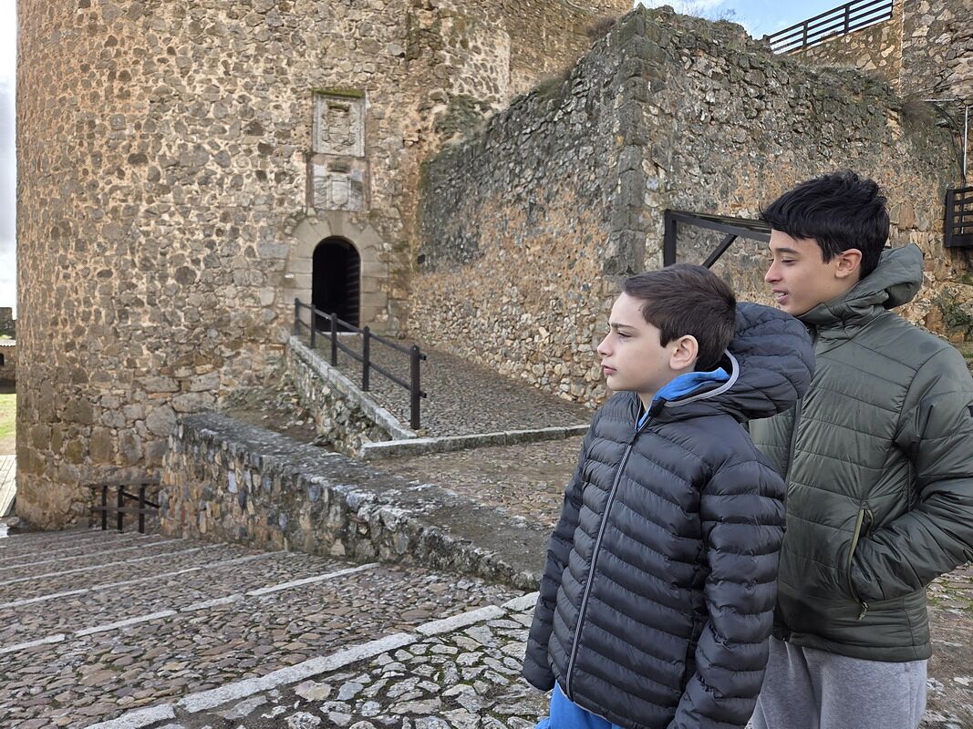 Nico y Bruno mirando la torre de piedra del castillo de Consuegra