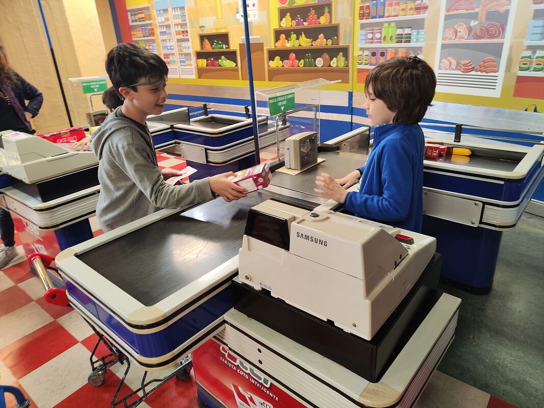Nico y Bruno atendiendo la caja del supermercado del Museo de los Niños del Abasto