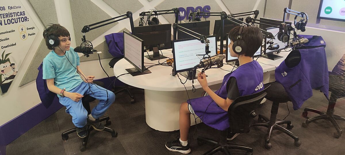 Nico y Bruno con auriculares delante de los micrófonos del estudio de radio de KidZania Santiago